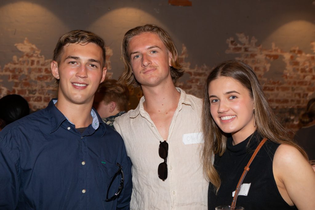 2 male and a female smiling and posing for the camera