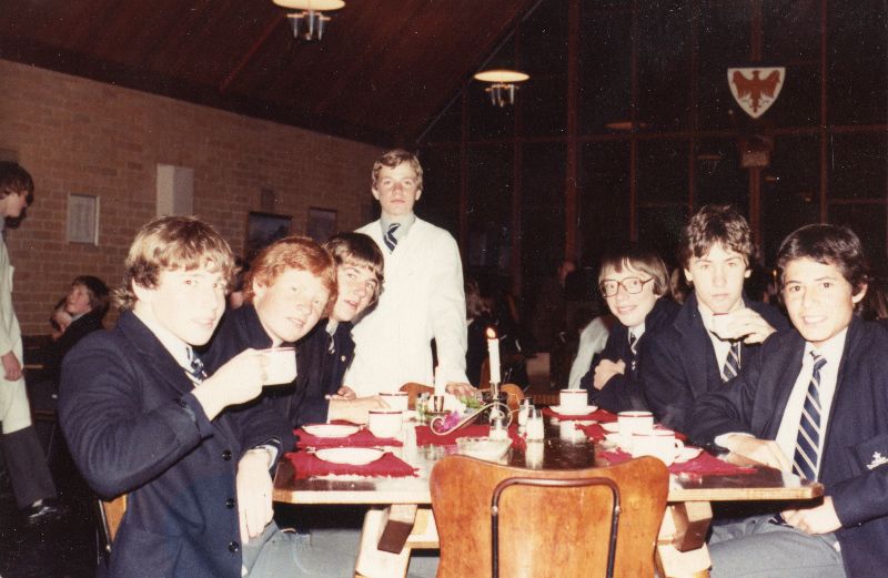 group of young men sitting around a table