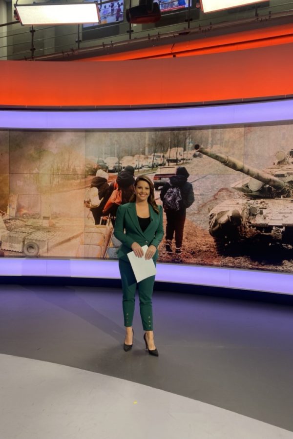 Emily Angwin standing in front of a picture of tanks