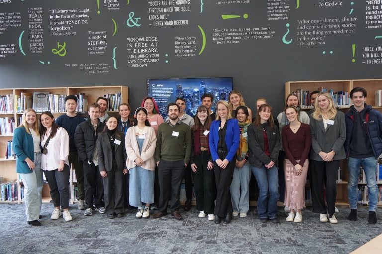 a group of people standing in front of a book shelf at the National Careers Week 2023