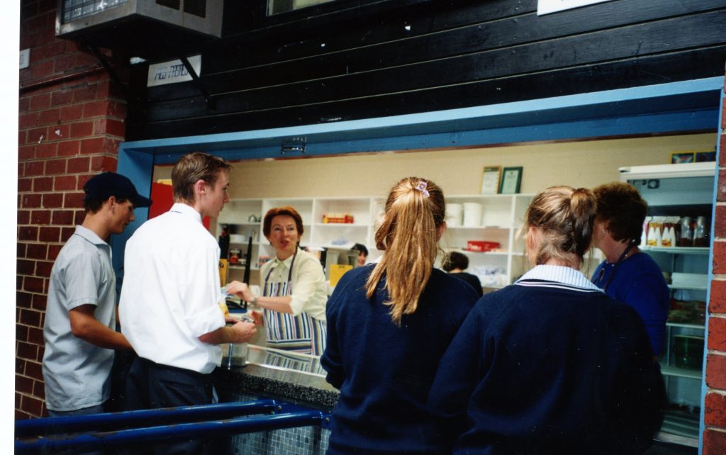 A group of people standing in front of a store.