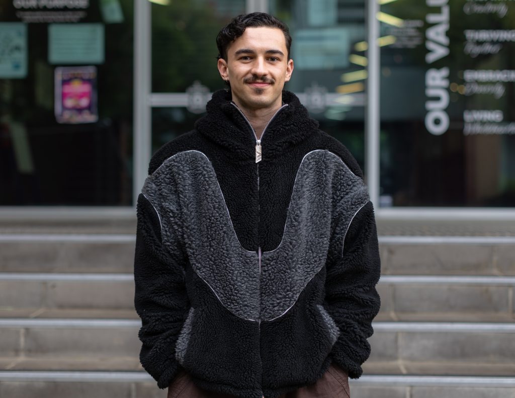 A man wearing a black and grey teddy bear jacket.